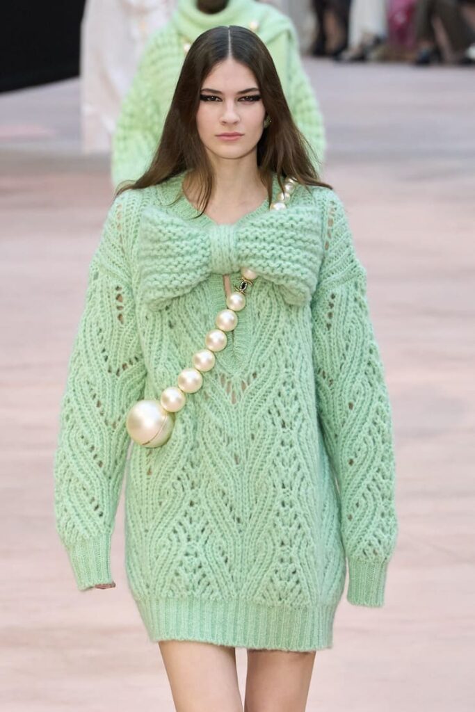 Modella con maxi pull con fiocco alla sfilata Chanel