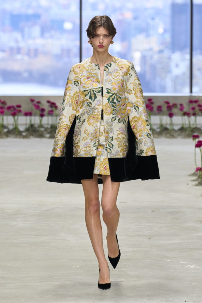 Una modella con una mantella in sfilata da Carolina Herrera