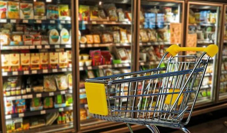 vetrina surgelati al supermercato e carrello della spesa