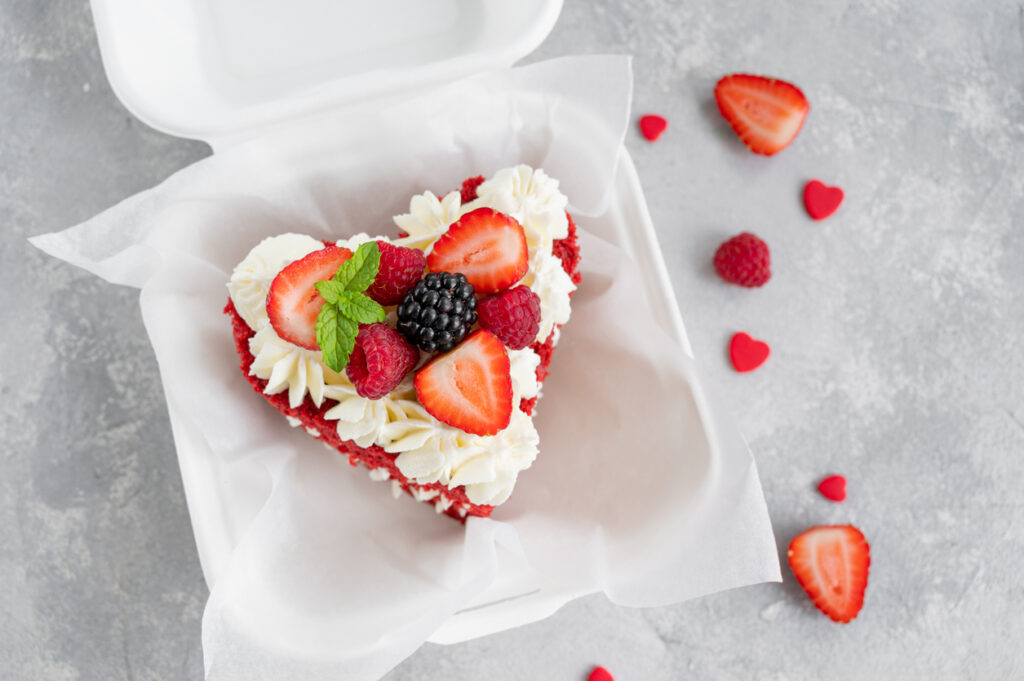 Dolce a forma di cuore con panna, fragole e more