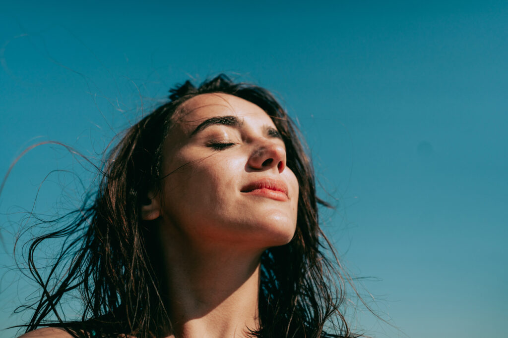 ragazza con occhi chiusi guarda il sole