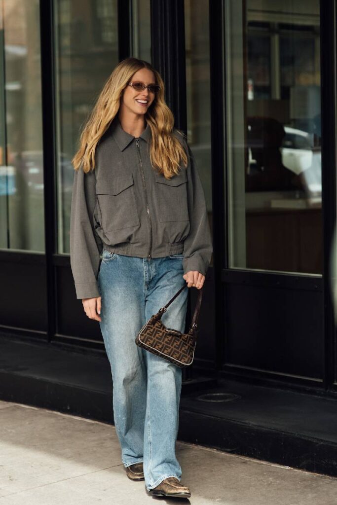 ragazza sorridente con giubbotto e jeans