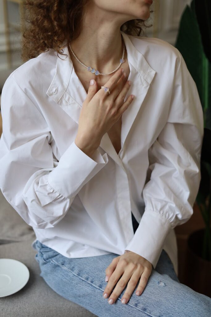 ragazza con camicia aperta sul collo e gioielli in vista