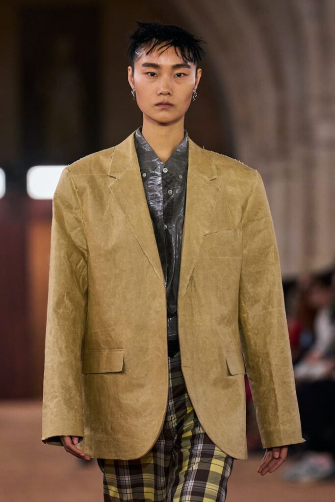Modella con blazer macchiato in sfilata Acne Studios