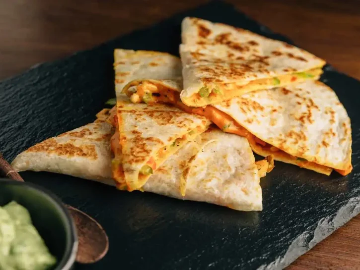 Quesadillas di pollo al forno e formaggio servite con salsa guacamole