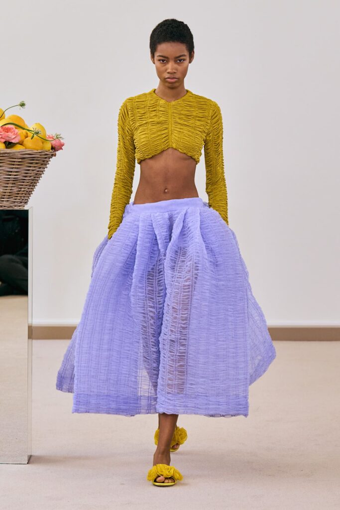 Modella con gonna lavanda abbinata a top oro