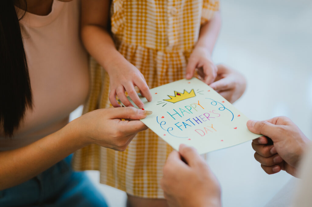 bambina porge il biglietto al pap&agrave; con gli auguri per la festa