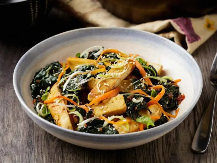 Piatto unico con tofu, cavolo saltato, carote e salsa vegana XO