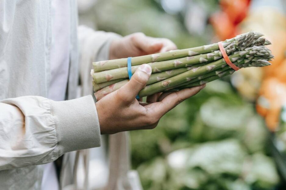 donna sceglie gli asparagi al supermercato