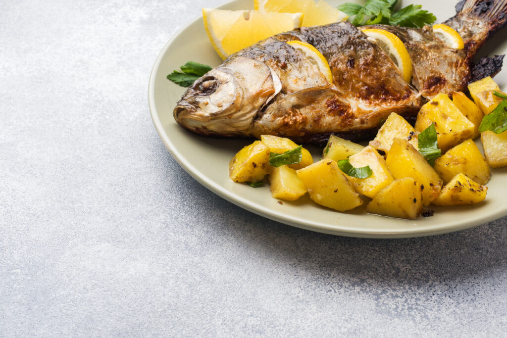 Sgombro alla griglia con patate e limone su piatto