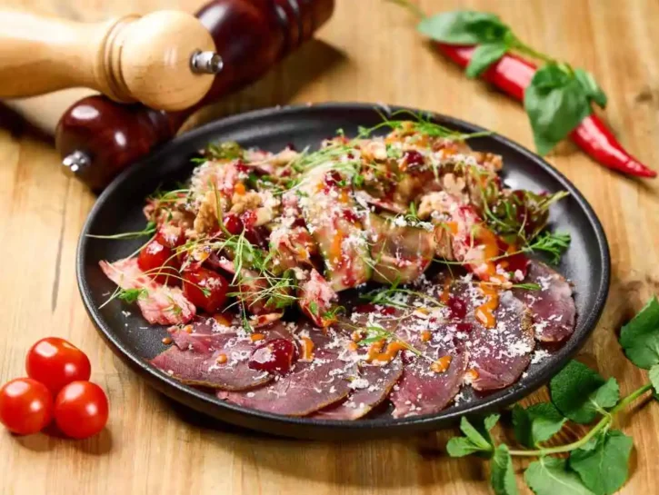 Insalata gourmet con carne essiccata, salsa al lampone e peperoncino e verdure fresche