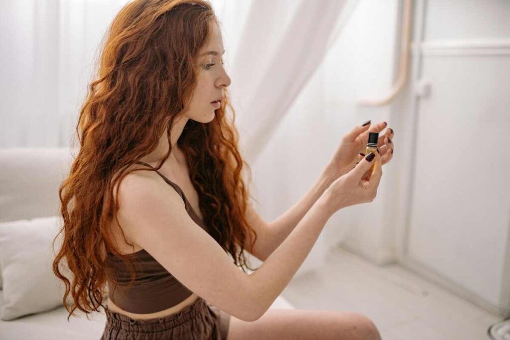 ragazza in bagno sta usando un olio per capeli