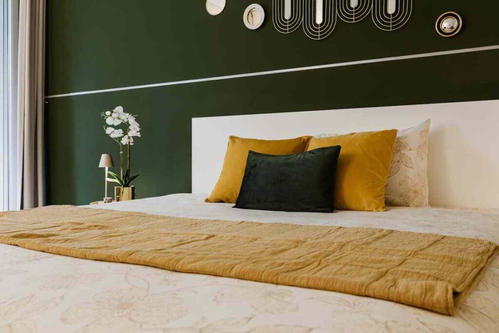 letto elegante con cuscini e coperta colorata