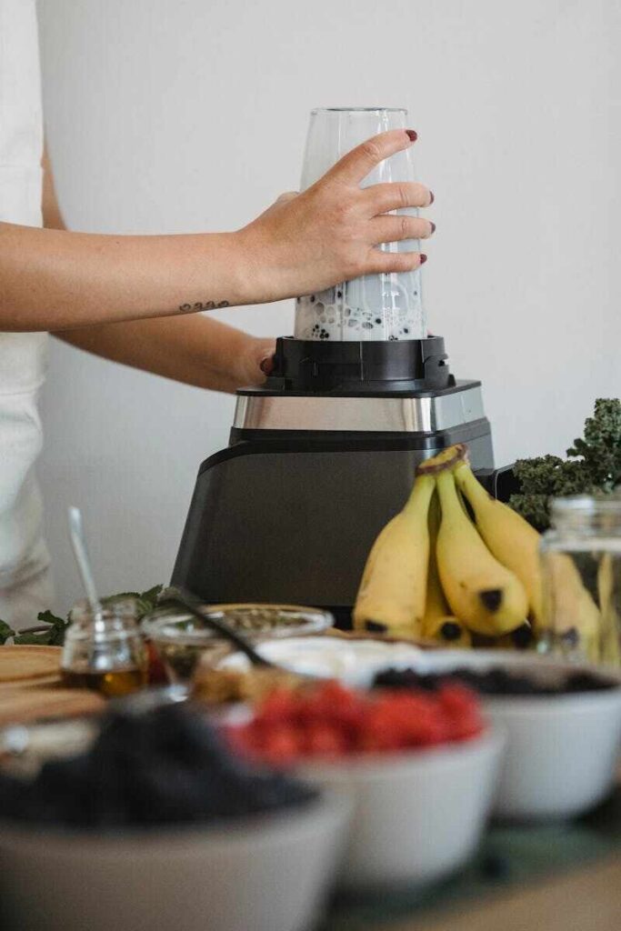 ragazza sta facendo un frullato col frullatore elettrico