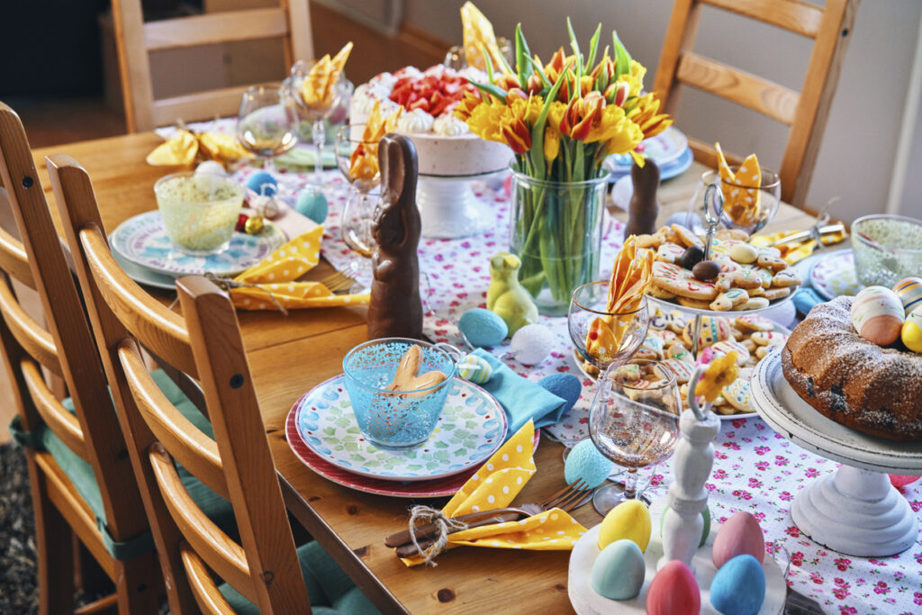 Tavola di pasqua con uova di Pasqua, biscotti, torta e fiori 