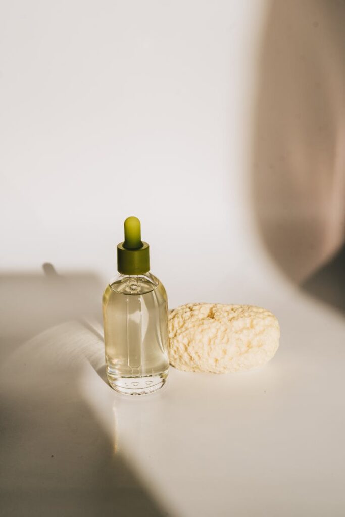 boccetta di olio essenziale di bellezza poggiato su tavolo