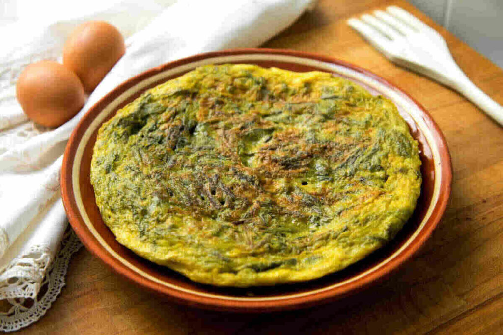 Frittata di agretti su piatto con uova sode vicino