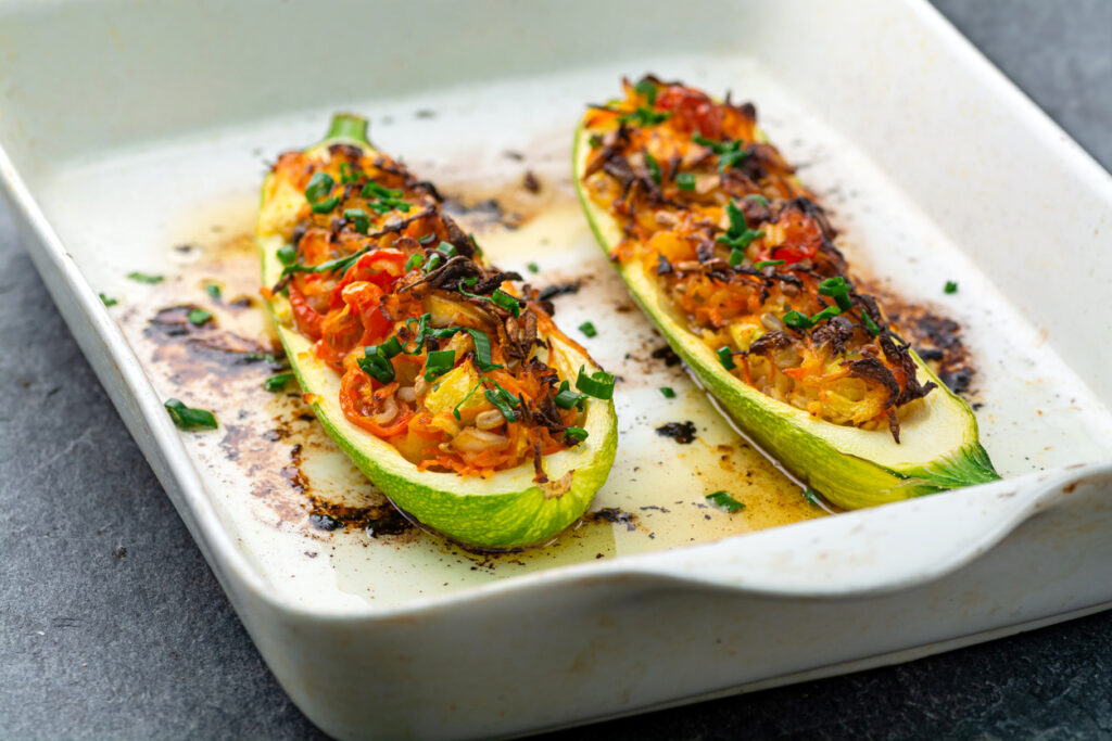 Zucchine ripiene con pomodoro e verdure su piatto
