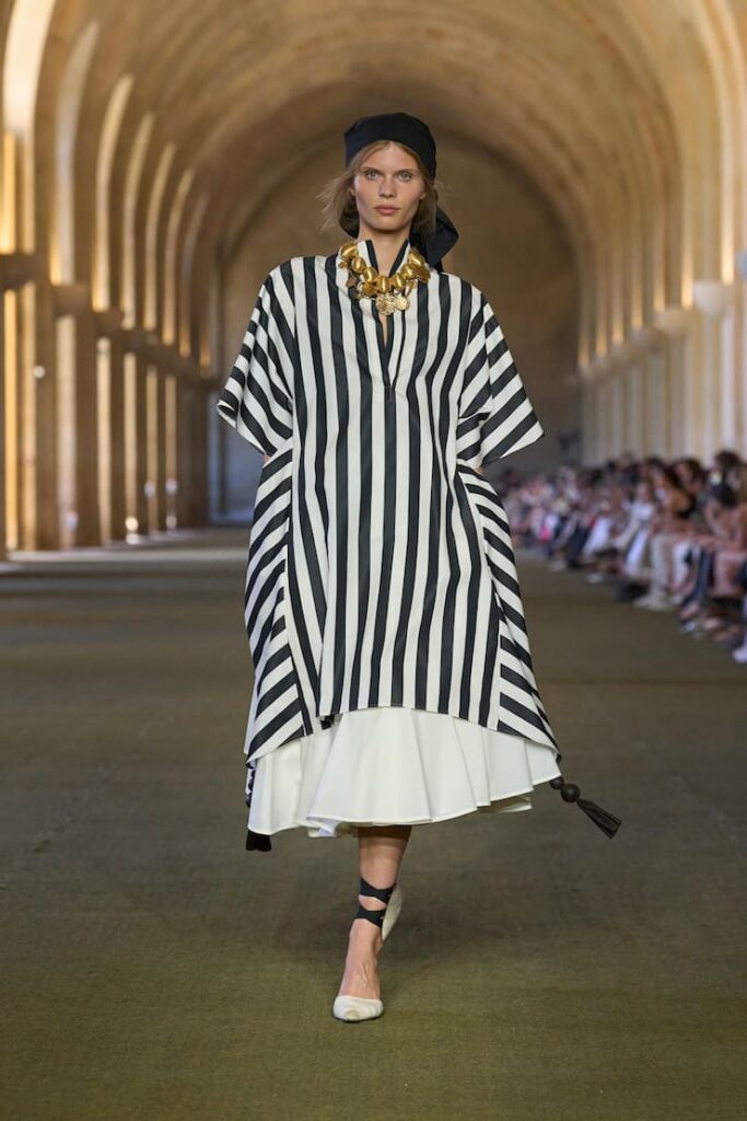 Modella alla sfilata di Jacquemus con abito a righe caban