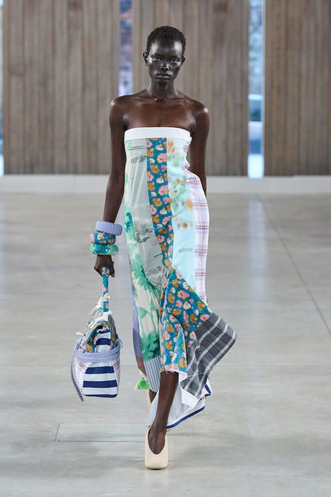 MOdella alla sgilata Moschino con abito stampa maxxing