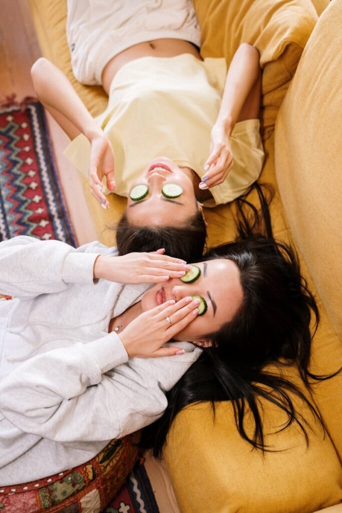 due ragazze sdraiate sul divano con i cetrioli sugli occhi