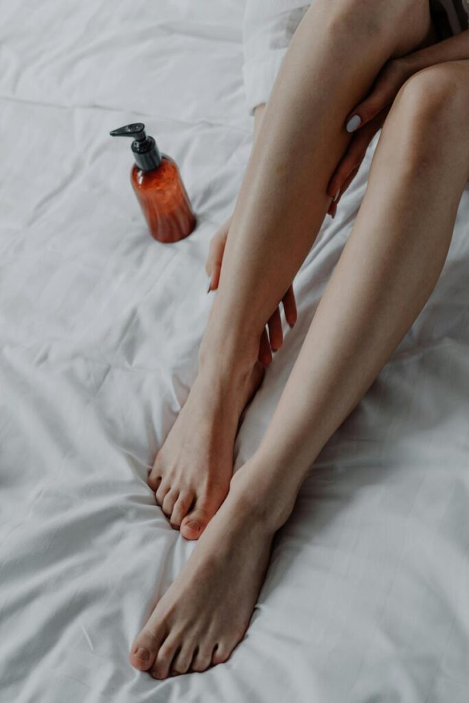gambe di donna che si mette olio