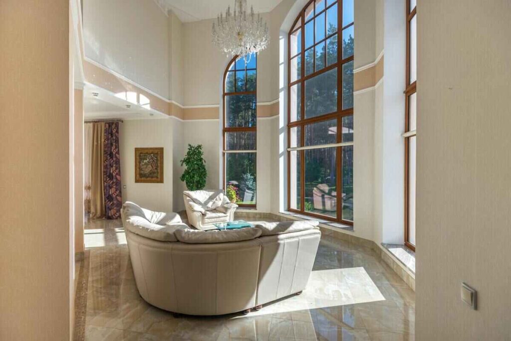 Salotto luminoso con divano bianco, lampadario chandelier e vetrate 