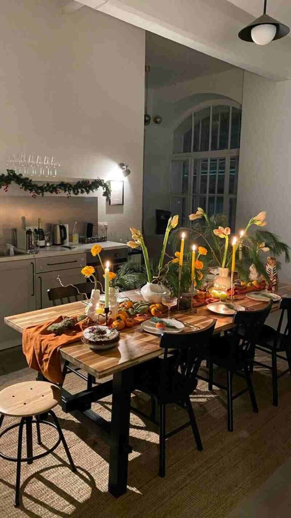 Tavolo da pranzo con sopra cibo, candele e fiori