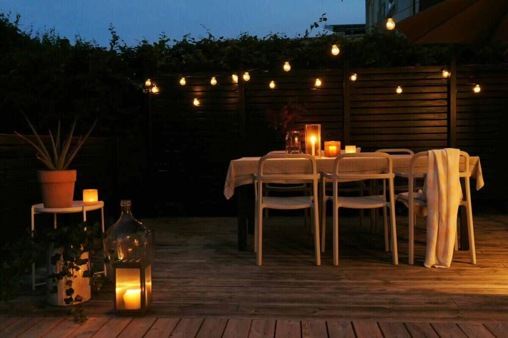 Terrazza di sera con tavolo e candele e luci che illuminano