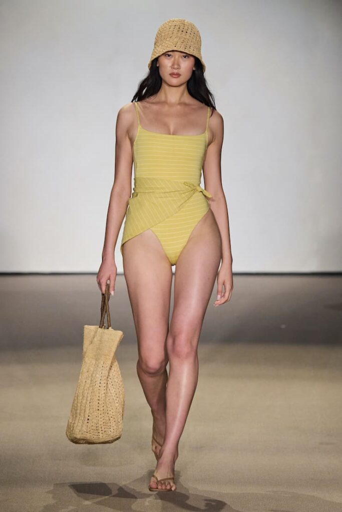 Modella con beach bag in paglia in sfilata