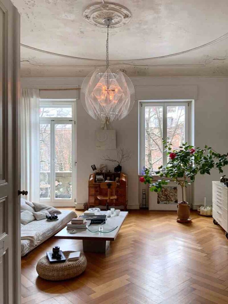 Salotto casa con tavolino basso, lampadario pendente, pianta, arredato in stile nordico