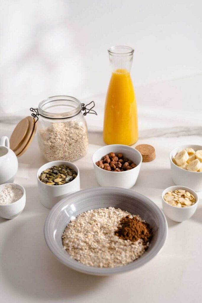 Tavola con ciotola di avena e cacao, ciotoline di frutta secca, succo d'arancia