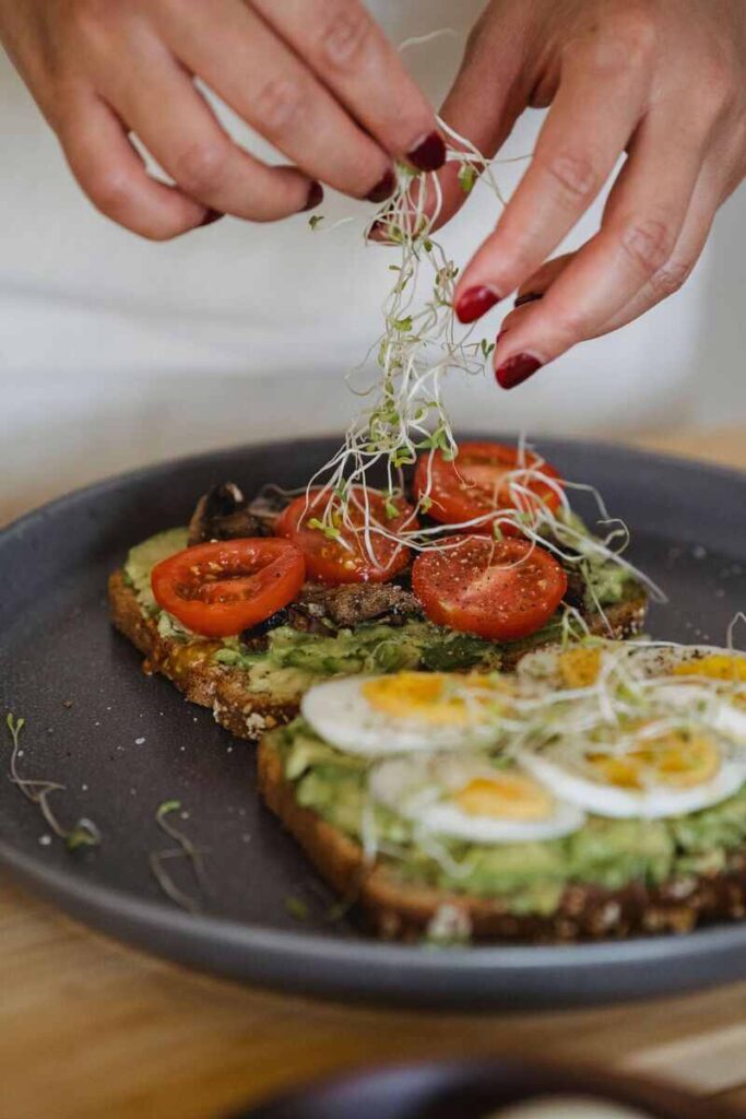 Piatto con due toast: uno con avocado e uova e uno con pomodorini