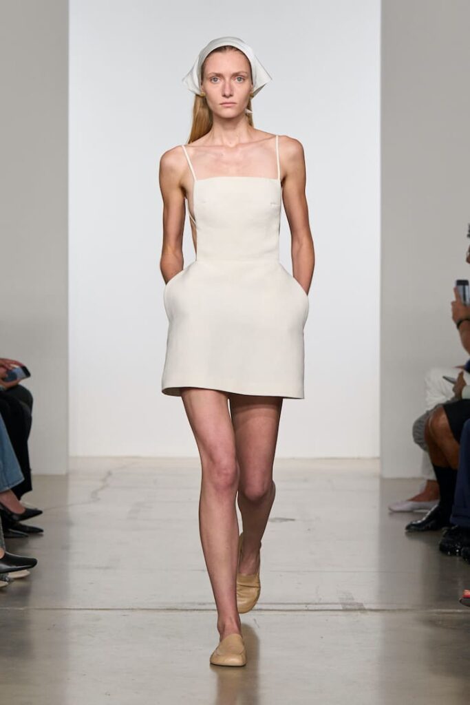 Modella con abito grembiule bianco
