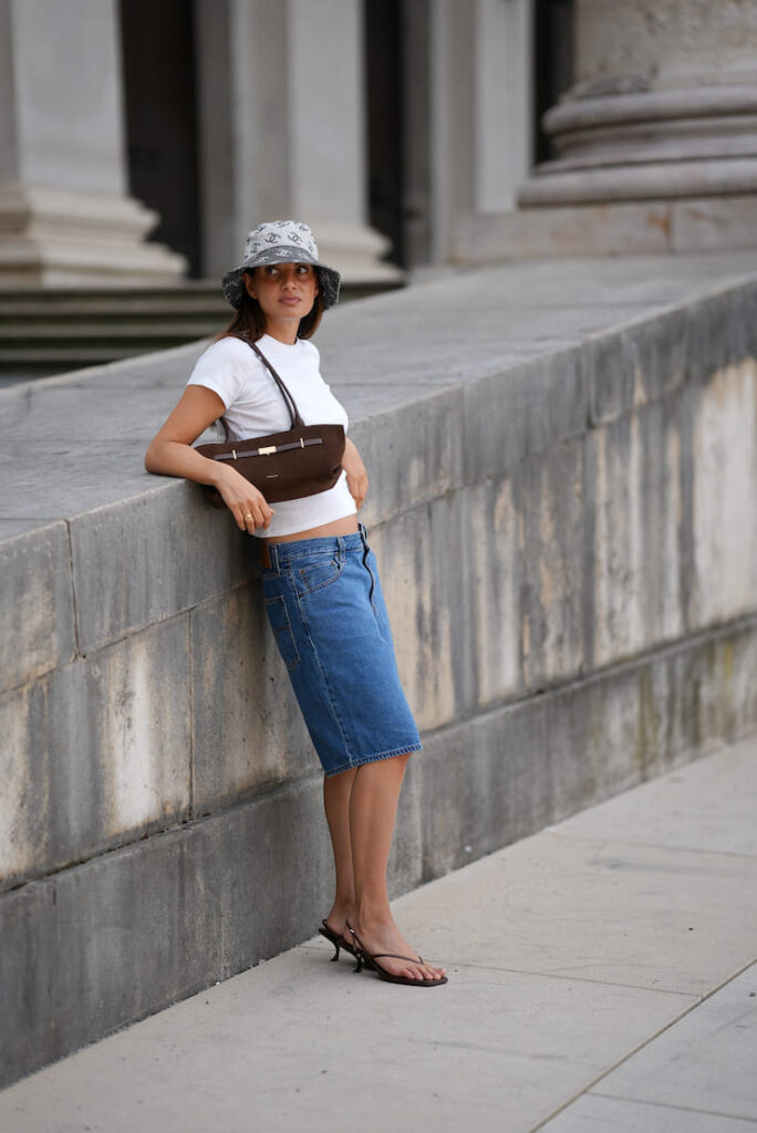 Ragazza con T-shirt, bermuda jeans e infradito con il tacco
