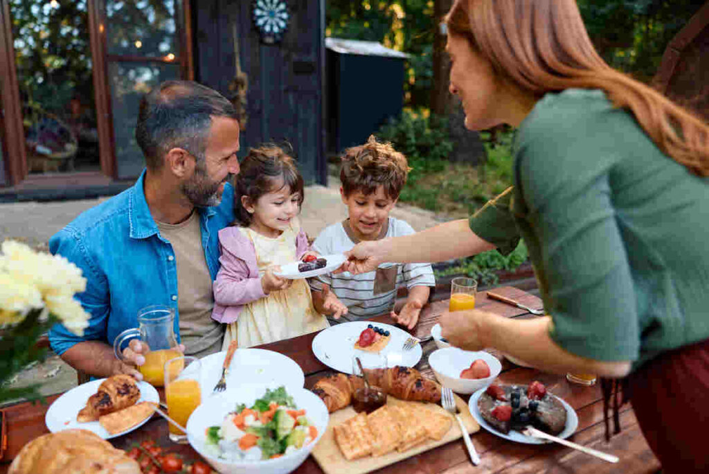 genitori e bambini che mangiano a pranzo, tavola bandita