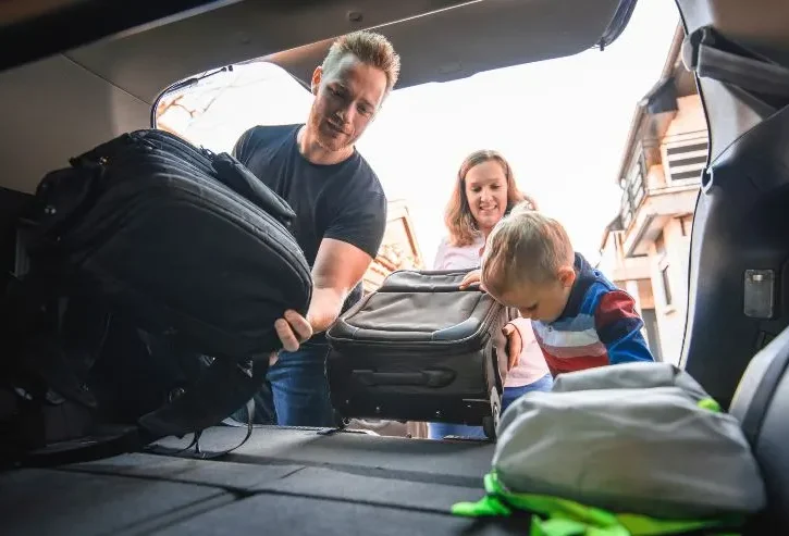 famiglia carica i bagagli in auto