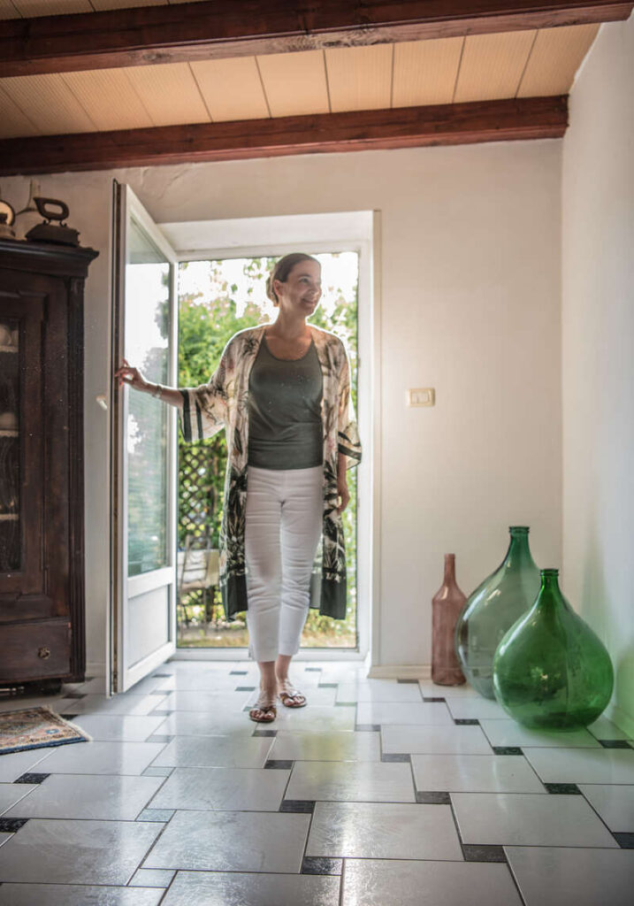 donna che entra in ingresso casa dalla porta