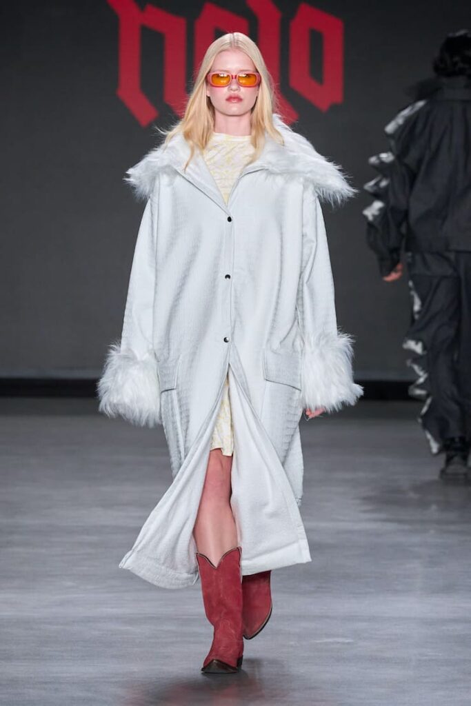 Modella con cappotto bianchi e stivali rossi