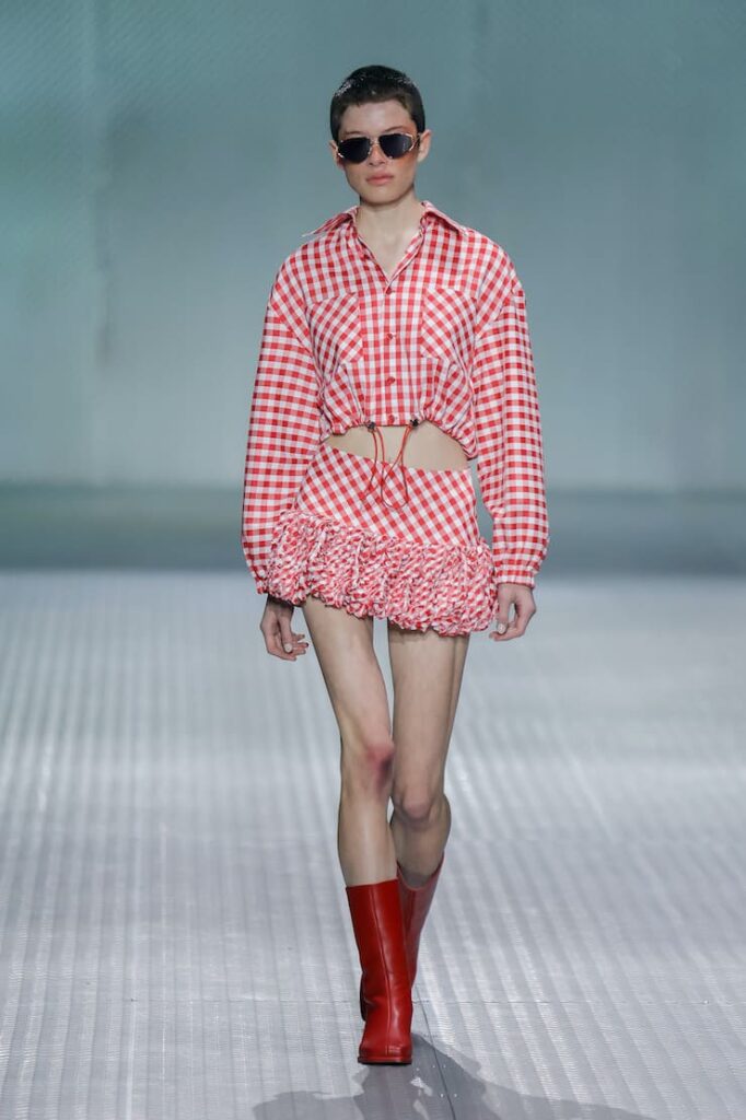 Modella con look a quadretti e stivali rossi