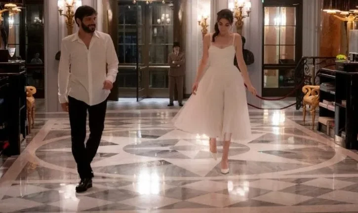 Pilar Fogliati (Eleonora) e Filippo Scicchitano (Valerio), camminano all'interno di una lussuosa hall di un hotel
