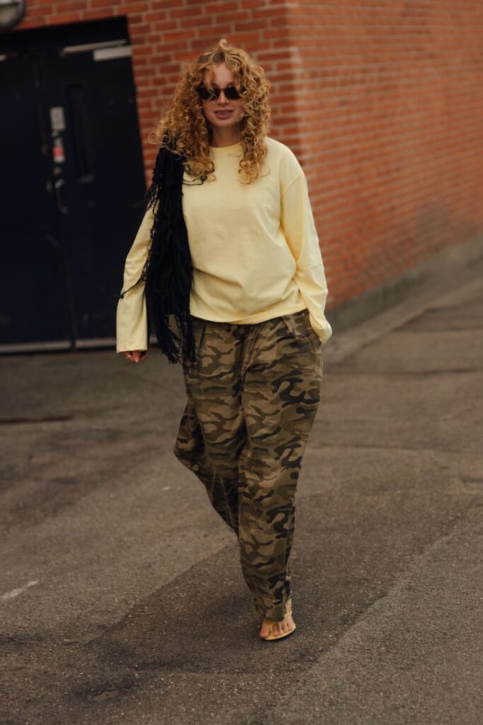 Ragazza co n maglioncino e pantaloni camo.
