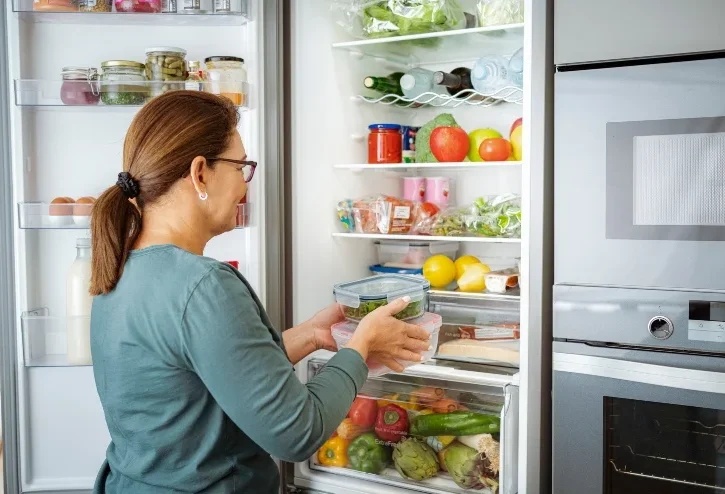 Una donna davanti al frigorifero aperto