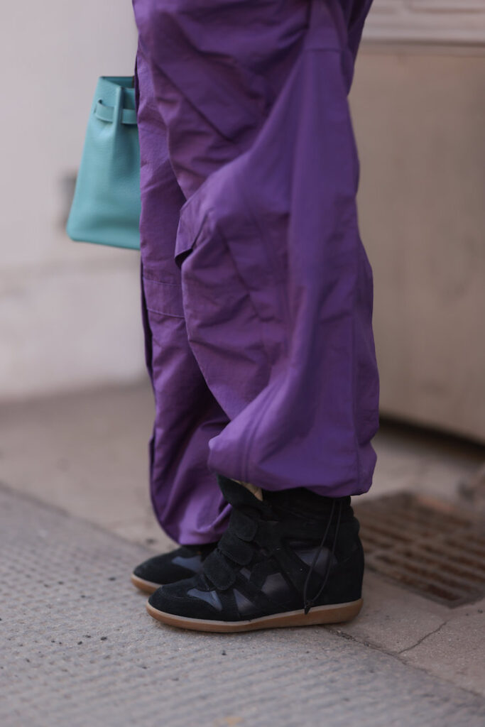 Wedge sneaker nere con pantaloni viola