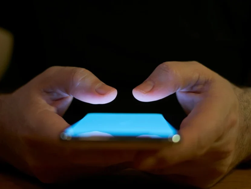 Le mani di un ragazzo digitano sullo schermo dello smartphone
