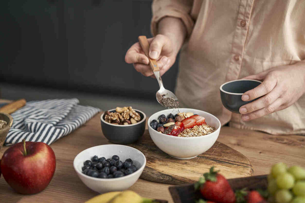 donna versa semini nella bowl con porridge