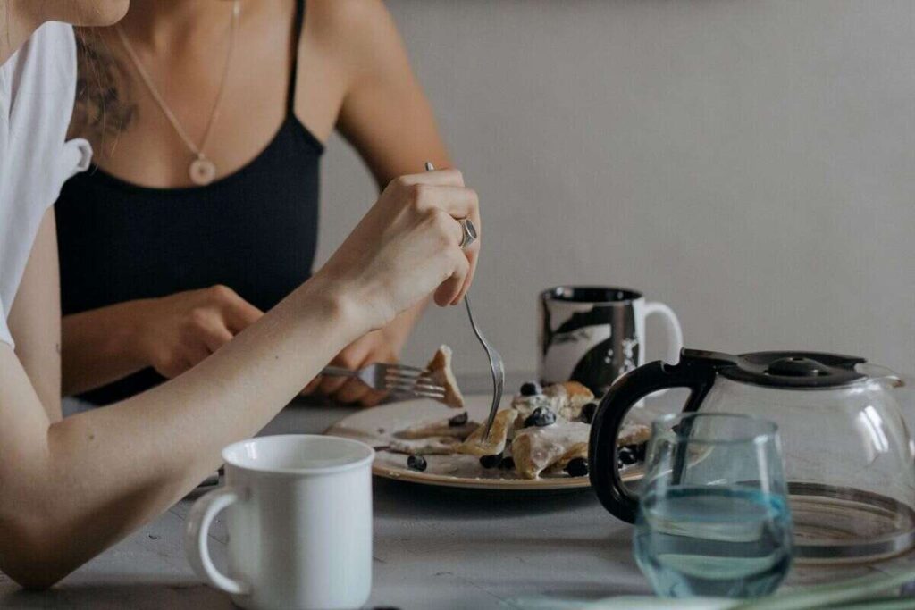 due ragazze che fanno colazione e mangiano pancake