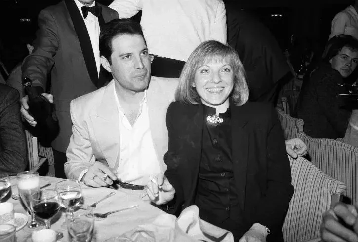 freddie mercury e mary austin sorridenti seduti in un ristorante
