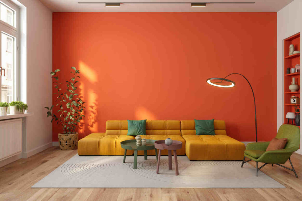 salotto con parete arancione e ampio divano