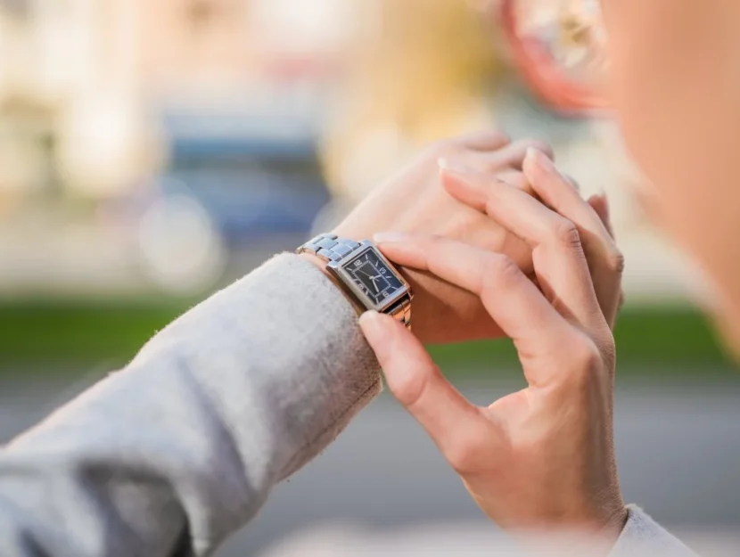 Le mani di una donna che controlla l'ora sull'orologio da polso